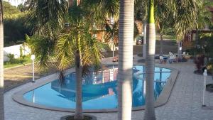 una piscina con palmeras en un complejo en Chalé Porto dos Lençóis, en Barreirinhas