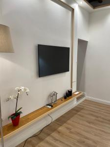 sala de estar con TV de pantalla plana en la pared en Elian Apartament In The Center of Rome, en Roma