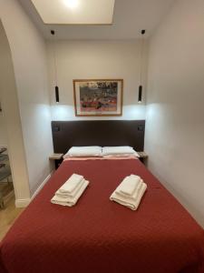a bedroom with a red bed with two towels on it at Elian Apartament In The Center of Rome in Rome