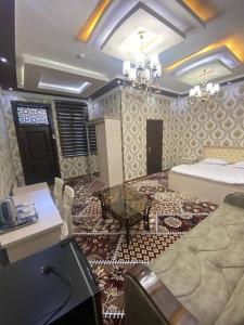 a living room with a bed and a table and a table at VOSTOK HOTEL in Bukhara
