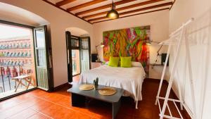 a bedroom with a bed and a painting on the wall at Hostel Plaza Mayor Corredera in Córdoba