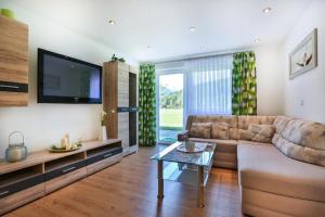 a living room with a couch and a tv at Ferienwohnung Haus Heimattreu in Schönau am Königssee