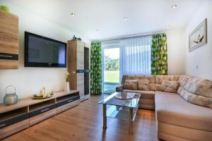 Una sala de estar con un sofá y un televisor. en Ferienwohnung Haus Heimattreu, en Schönau am Königssee