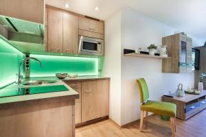 una cocina verde con fregadero y silla en Ferienwohnung Haus Heimattreu, en Schönau am Königssee