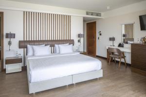 a bedroom with a large white bed and a desk at Spektr Boutique Hotel Yalikavak in Yalıkavak