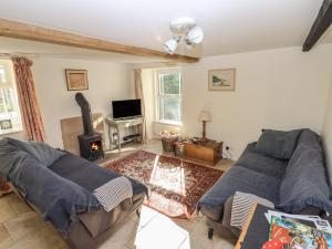 sala de estar con 2 sofás y chimenea en Park Cottage, en Matlock