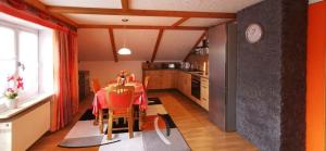 eine Küche mit einem Tisch mit Stühlen und einer Uhr in der Unterkunft Landhaus Simon in Gleißenberg