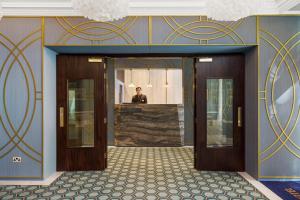 a man is standing in the doorway of a building at Commodore Hotel in London