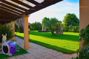 un jardín con un parque infantil con un juguete en el suelo en La Fontana Dei Desideri en Alghero