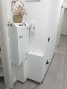 - un réfrigérateur blanc assis à côté d'un mur dans l'établissement Apartmani Dojčinović, à Vranje