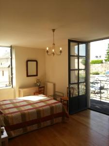 a bedroom with a bed and a sliding glass door at Le Relais de la Tour in Figeac