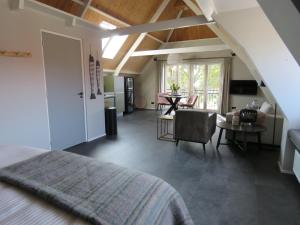 a bedroom with a bed and a living room at Appartement de Hoge Stoep in Hollum