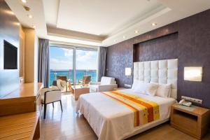 a hotel room with a bed and a view of the ocean at Konstantinos Palace in Karpathos