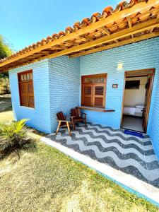 uma casa de tijolos azuis com uma mesa e duas cadeiras em Sunshine Inn Centro em Cumbuco