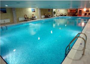 a large swimming pool with blue water in a hotel at Гранд Манастира Апартаменти "Зимна приказка" in Pamporovo
