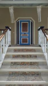 a hallway with stairs with a blue door and a doorway at Villa Christa in Arillas