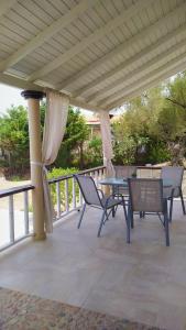 un patio con sillas y una mesa en una terraza en Villa Christa, en Arillas