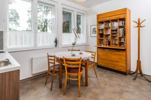 a kitchen with a table and chairs and windows at APARTMÁNY VILA LIBĚNA in Ostrava