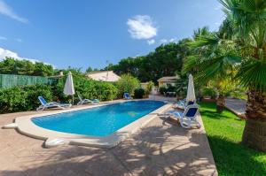 una piscina con tumbonas y sombrillas en YourHouse Oratge villa with pool, en Santa Margalida
