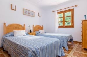Dos camas en una habitación con paredes blancas y una ventana. en YourHouse Oratge villa with pool, en Santa Margalida 32 fotos más