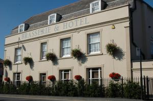 a white building with flowers in the windows at Le Bouchon Brasserie & Hotel in Maldon