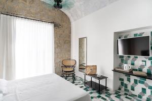 a bedroom with a bed and a tv and a chair at Miramare Sea Resort & Spa in Ischia