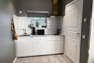 a kitchen with white cabinets and a window at Killeröd Boutique Apartments in Båstad +18 photos