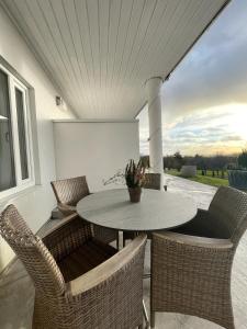 a patio with a table and chairs with a view at Killeröd Boutique Apartments in Båstad