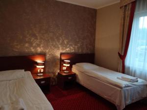 a hotel room with two beds and a window at Hotel TiM in Cekanowo