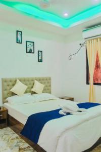 1 dormitorio con 1 cama grande y techo azul en Zcube Andaman, en Port Blair
