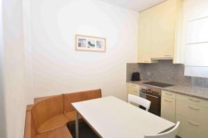a small kitchen with a white table and chairs at 2BR flat near lake and central - Stardust 22 in Zurich