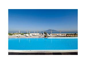 une grande piscine bleue avec vue sur l'océan dans l'établissement Towers Hotel Stabiae Sorrento Coast, à Castellammare di Stabia