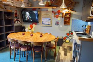 a kitchen with a wooden table with chairs and a television at RisoulSki Constellation in Risoul