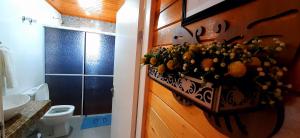 a bathroom with a vase of flowers on the wall at Pousada Estrela Do Luar in Urubici +97 photos