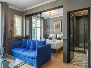 uma sala de estar com um sofá azul e uma cama em The Blue King Suite em Paris