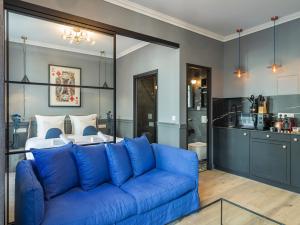 uma sala de estar com um sofá azul em frente a uma cama em The Blue King Suite em Paris