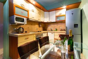 a kitchen with a glass table with a bottle of wine at Residence Art Guest House in Plovdiv
