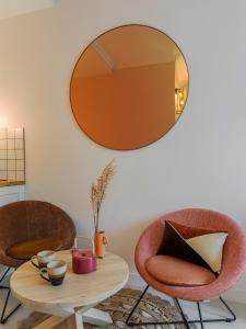 um quarto com duas cadeiras e uma mesa com um espelho em Pink & Wood cocoon em Paris
