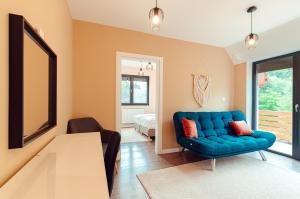 ein Wohnzimmer mit einem blauen Sofa und einem Tisch in der Unterkunft Selters Guesthouse in Lueta