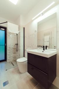 a bathroom with a sink and a toilet and a mirror at Selters Guesthouse in Lueta