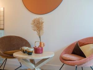 uma mesa com uma planta e duas cadeiras em Pink & Wood cocoon em Paris