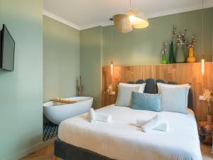 a bedroom with a large bed and a bath tub at Nature and Haven of Peace Apartment in Paris