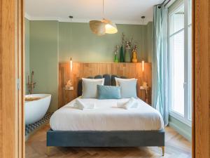 ein Schlafzimmer mit einem großen Bett und einer Badewanne in der Unterkunft Nature and Haven of Peace Apartment in Paris