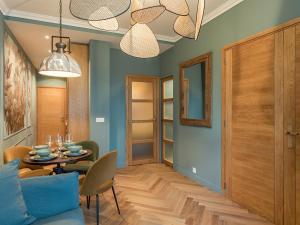 ein Esszimmer mit blauen Wänden sowie einem Tisch und Stühlen in der Unterkunft Nature and Haven of Peace Apartment in Paris