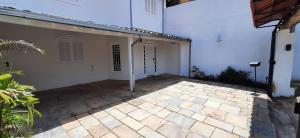 an empty courtyard of a white house with a patio at Dikasa Alugue Temporada in Ouro Preto