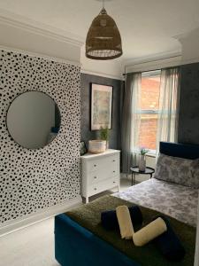 a bedroom with a bed and a mirror on the wall at House of cosy dots in Northampton