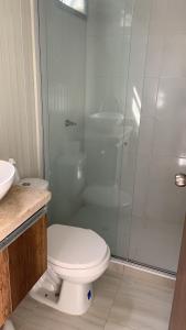 a bathroom with a toilet and a glass shower at Minca Seasons in Minca