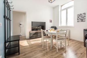 una cucina e una sala da pranzo con tavolo e sedie di Appartement moderne, propre, WIFI, siège massant a Roncq