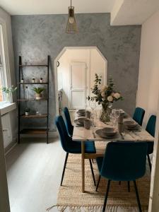 a dining room with a table and blue chairs at House of cosy dots in Northampton