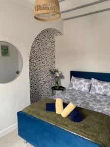 a bedroom with a blue bed and a mirror at House of cosy dots in Northampton
